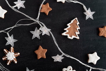 Christmas cookies stars, fir tree and Garland on black background. Gingerbreads