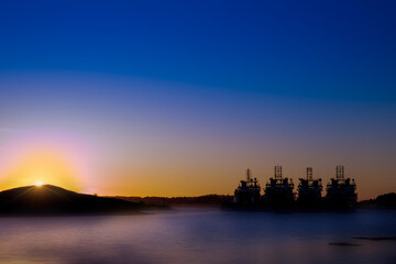Silhouette of shipping vessels at sunset