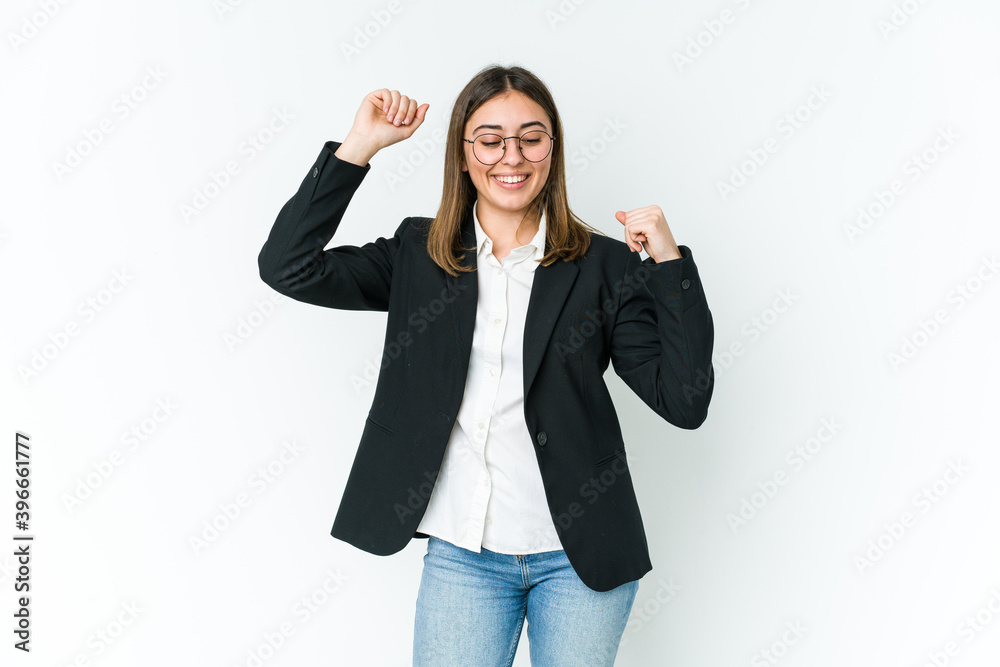 Wall mural young caucasian business woman celebrating a special day, jumps and raise arms with energy.