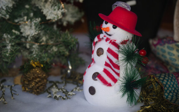 Mini boneco de neve com chap&eacute;u e cachecol em ambiente natal&iacute;cio