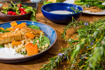 Grilled vegetables and healthy food dishes on a fancy wooden table. Mediterranean food dishes with asparagus, tofu, seitan and Halloumi cheese. Gluten free recipes for fitness persons. Food Background