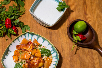 Healthy plate with fried vegetarian tofu and greek halloumi with grilled vegetables and yogurt sauce. Mediterranean food dishes with oriental couscous. Lemons and hot peppers around in decorative way