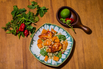 Healthy plate with fried vegetarian tofu and greek halloumi with grilled vegetables and yogurt sauce. Mediterranean food dishes with oriental couscous. Lemons and hot peppers around in decorative way