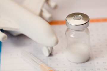 Glass vaccine vial, with syringe, and plane, in calendar 2021