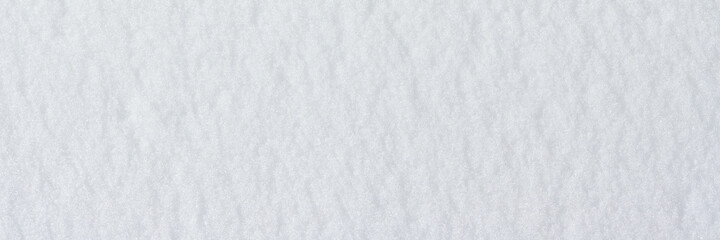 Natural snow texture. Smooth surface of clean fresh snow. Snowy ground. Winter background with snow patterns. Closeup top view. Wide panoramic texture for background and design.