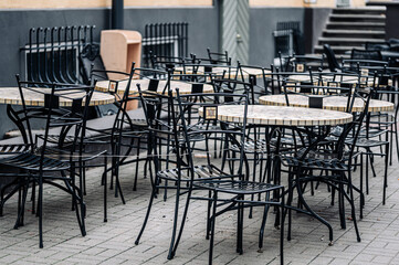 Empty tables in the outdoor cafe. Deserted street cafe in autumn.