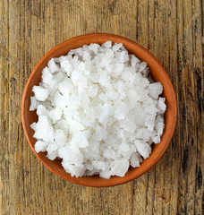 white salt in the cup on wooden