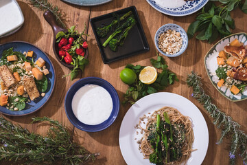 Grilled vegetables and healthy food dishes on a fancy wooden table. Mediterranean food dishes with asparagus, tofu, seitan and Halloumi cheese. Gluten free recipes for fitness persons. Food Background