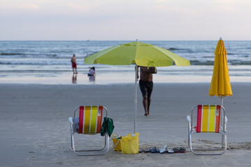 Cadeiras de praia e guarda-sol amarelo em praia do litoral brasileiro