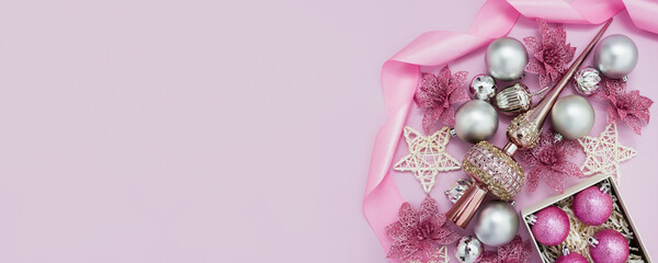 Pink Christmas balls and decor on pastel background. New Year's banner for beauty salons. Flat lay, copy space.