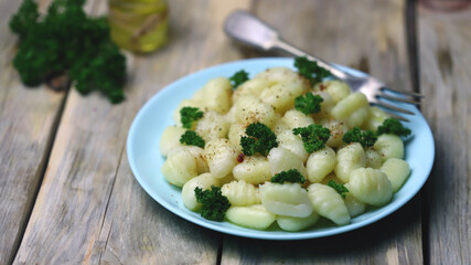 Selective focus. Macro. Gnocchi with olive oil and spices on a plate. A serving of gnocchi.
