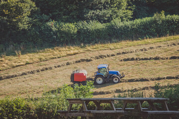 Tractor working on the farm in the Restormel castle surrounding landscape., Uk.