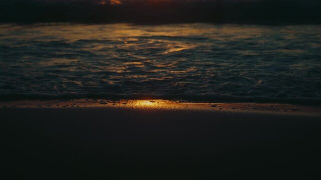 Small waves breaking on the shore at sunrise in Tulum Mexico