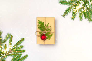 Christmas or New year handmade present decorated with craft paper, fir tree branch and ball on white background. Holiday concept. Flay lay, top view