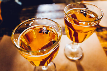 Christmas mulled wine apple cider with spices cinnamon sticks, cloves, anise and honey on rustic...