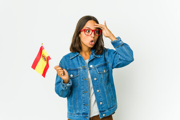 Young spanish woman holding a flag isolated on white background