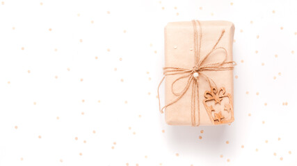 Nice present wrapped in craft paper and wooden decor on white background with copyspace, flat lay