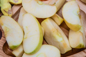 Healthy food: slices of apple on a white saucer, grains from apples on wooden gray background. Top view