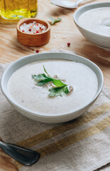 Mushroom cream soup in gray bowls with parsley on wooden background