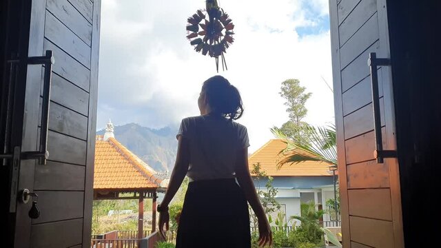 Back view of young woman opening doors while walking out from hotel to enjoying nature view. Shot in 4k resolution