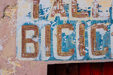 old rusty bicycle sign in concrete wall