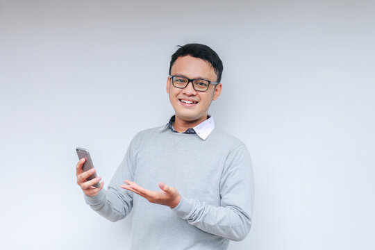 Smart Young asian man is happy and smiling when using smartphone in studio background