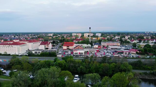 Aerial view overlooking traffic on a road and the village of Raunheim, cloudy evening, in Germany - orbit, drone shot