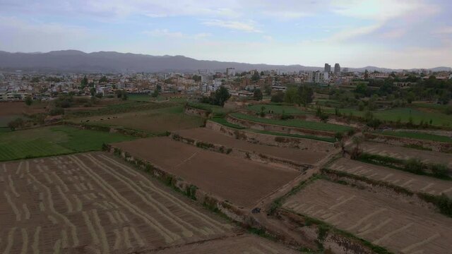 Drone flying over some very well organized crops in the countryside of the city of Arequipa-Peru, at the end you can see the track next to the plots.