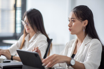 Fototapeta premium Young asian business woman meeting to work and using digital tablet with their colleagues in the office.