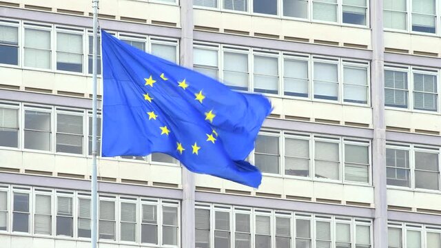 European flag waving in front of a grey building