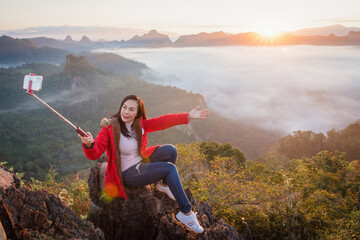 Fototapeta na wymiar A beautiful woman taking a selfie on Phu Pha Mok Ban Jabo in Mae Hong Son Province, Thailand.