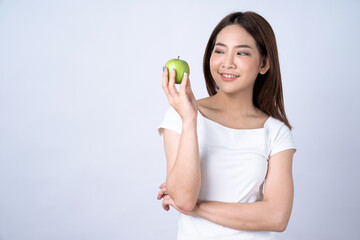 Beautiful asian girl holding a green apple on a white background.