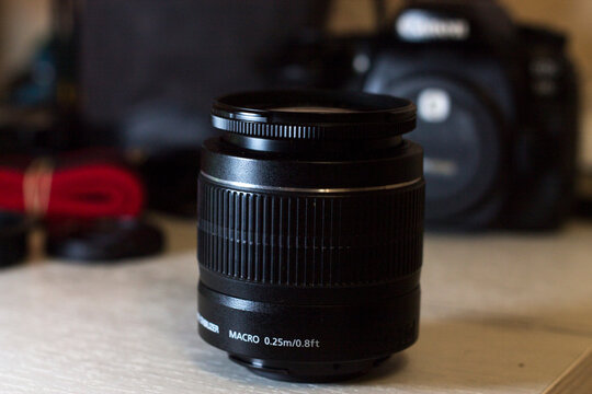 Lens on the table and a camera in the background