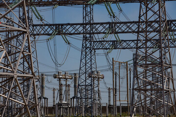 Electric pylons and wires. Distributing substation close-up.  Blue sky background.