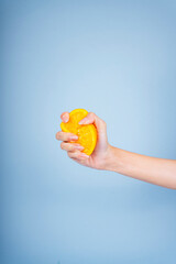 Hand of woman squeeze slice of orange.