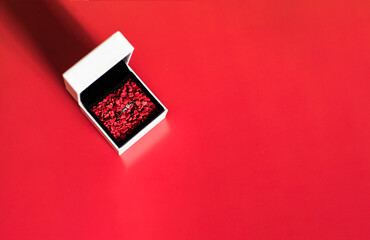 Ring in a white box on a red background. Photo taken with selective focus and noise effect
