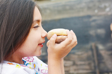 Happy latin little girl holding traditional buns.
