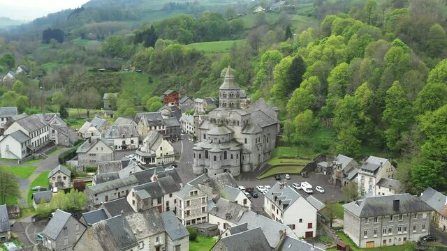 Beautifully dramatic Romanesque church surrounded by a vivid green valley.