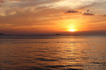 landscape photo of sunset reflect over the sea with clouds in the sky at the beach with shadow of rocks in the summer at Pattaya beach Thailand