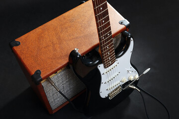 Naklejka premium Guitar combo with black guitar on black background.