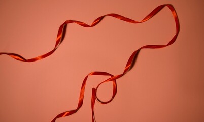 Long red ribbon on a pink background