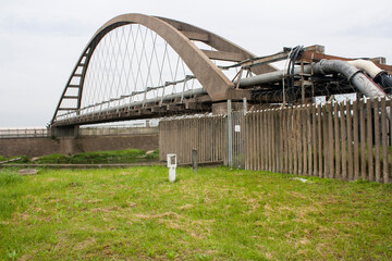 Arched Bridge Carrying Pipes Across Wide Canal