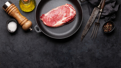 Raw beef ribeye steak on frying pan