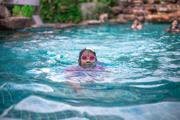 Close-up background angle Of Asian girls playing in the water or practicing swimming in the pool during summer vacation