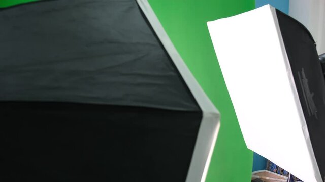 Studio soft light on tripod stand. Lighting studio equipment. Green screen. Close up shot.