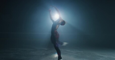 Cinematic shot of young female artistic figure skater is performing a woman's single skating choreography on ice rink before start of a competition. Concept of perfection, precision, freedom, passion.