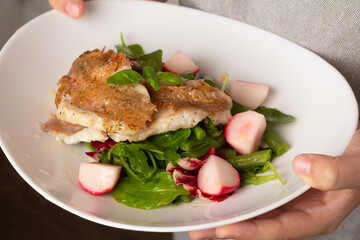 fried perch with vegetables on a plate close-up.