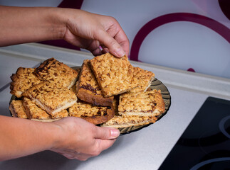 Viennese cookies are sliced and placed by hand on a plate.