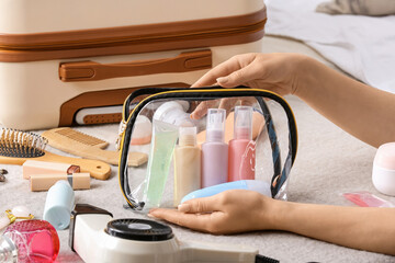 Female hands and bag with travel cosmetics kit