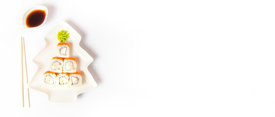 Funny edible Christmas tree made from sushi, creative idea for japanese restaurant on white background. New Year food background top view